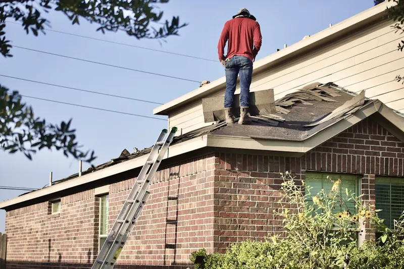 Professional roofer working on a residential roof in Saybrook